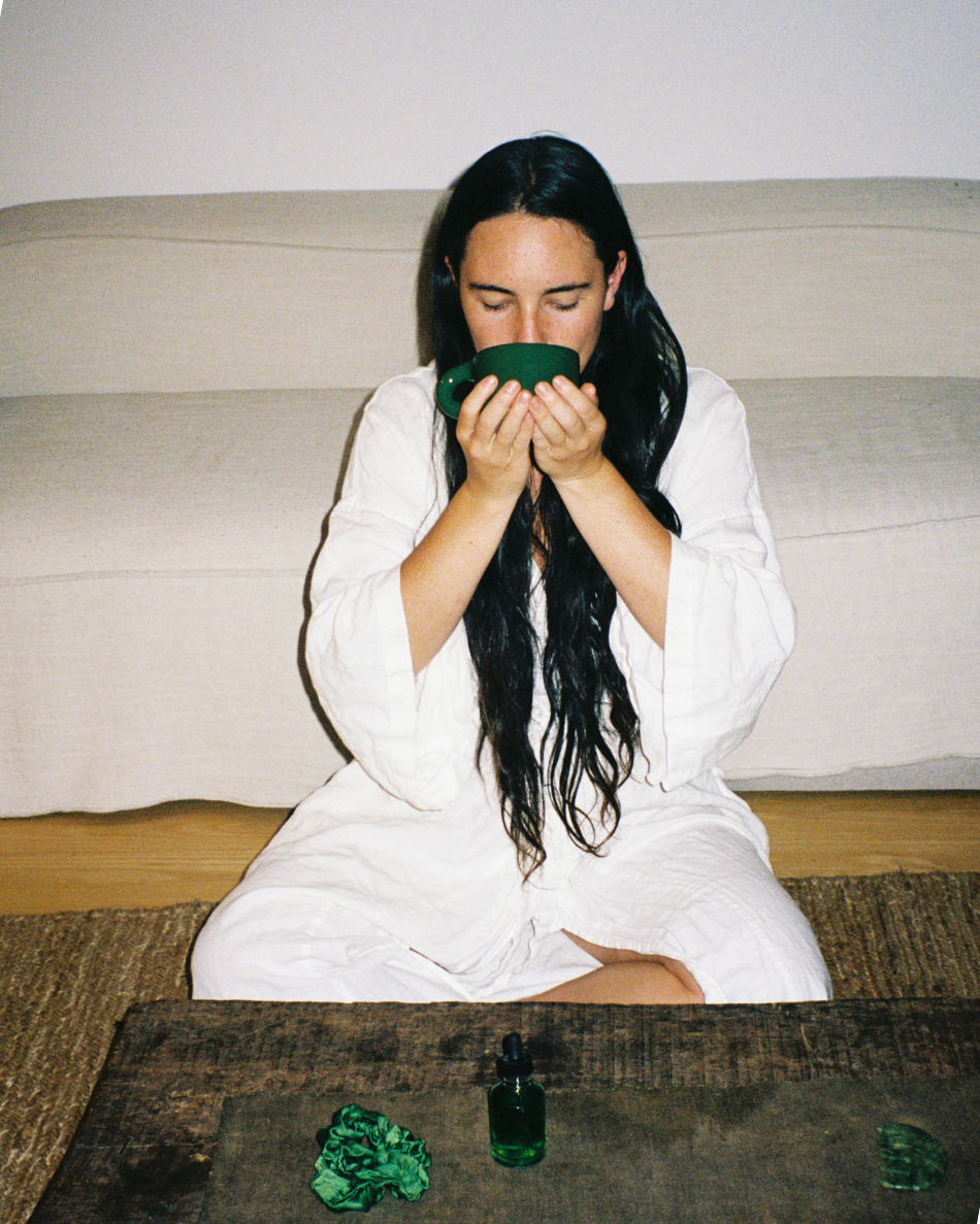 Woman holding the green HINU Ritual Mug in both hands