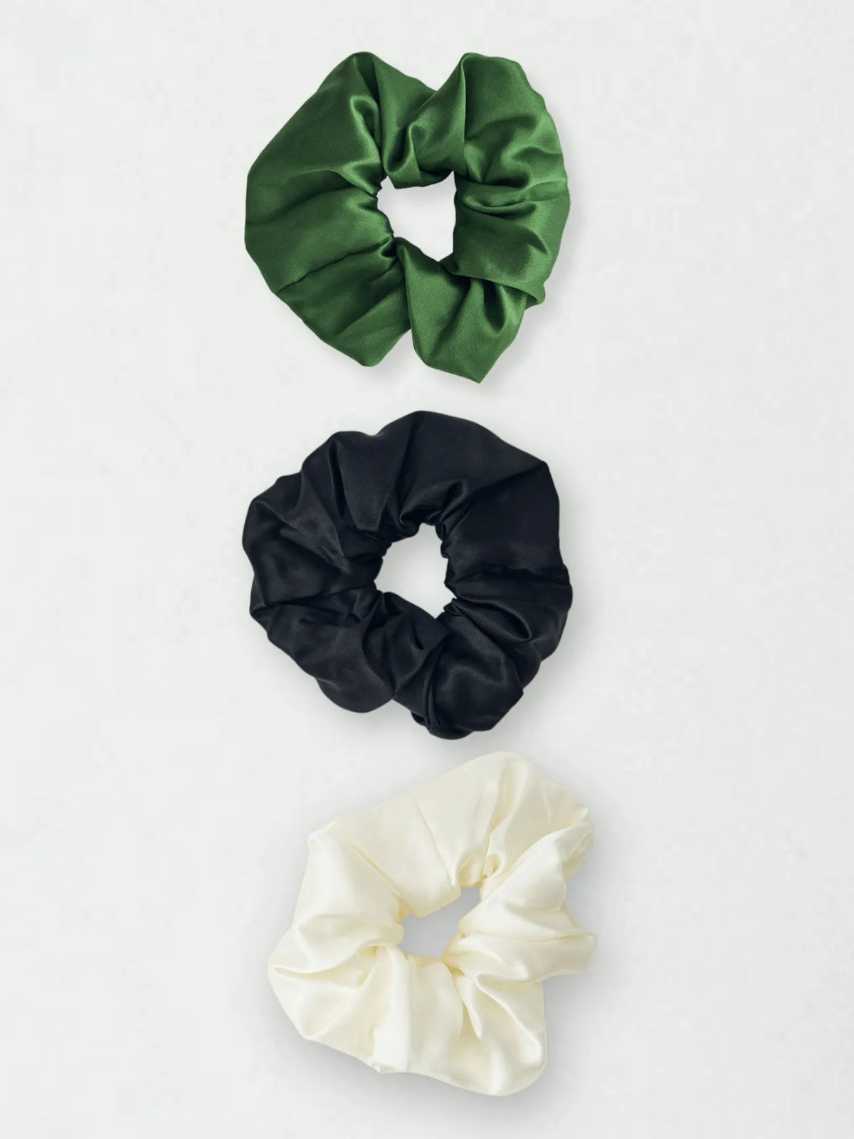 Three HINU Silk Scrunchies in forest green, black and cream