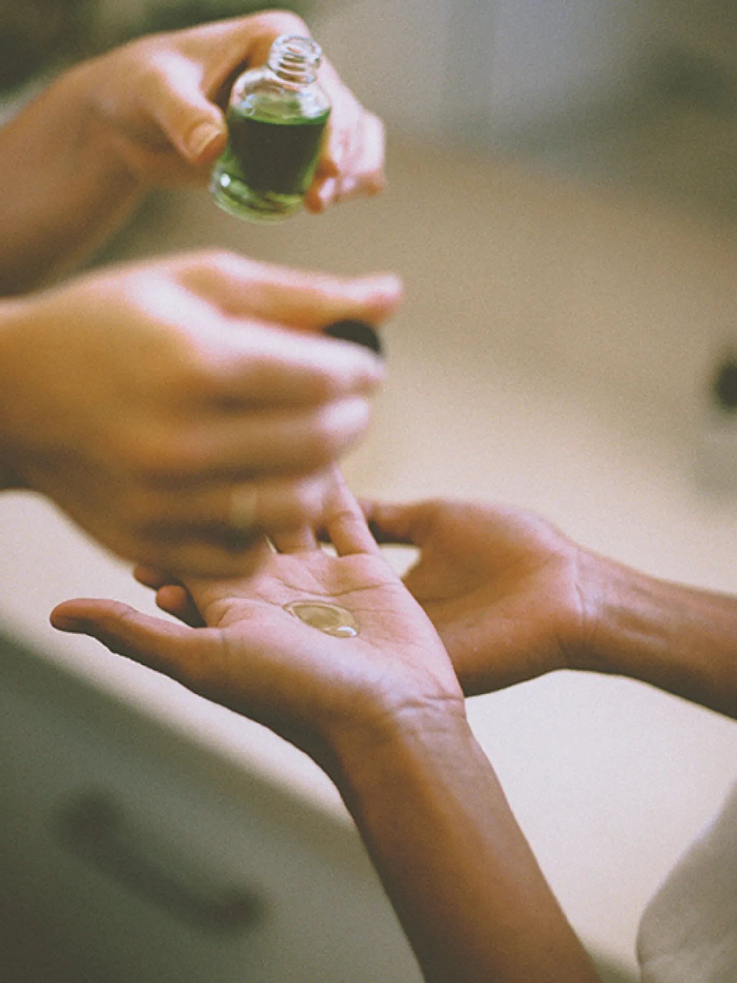 Woman dispensing HINU Hair Growth Oil from the bottle into her palm