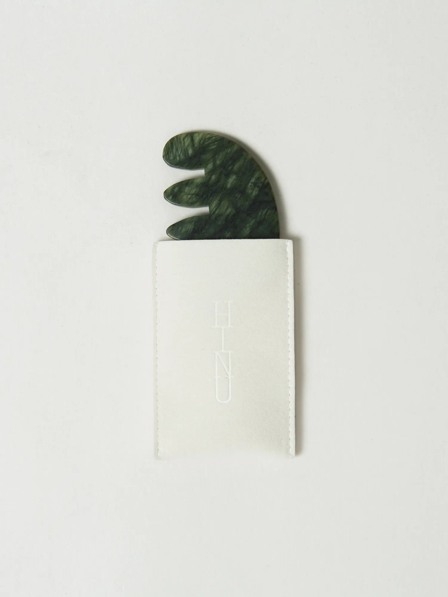 HINU Jade Scalp Stimulator partially tucked into its cream storage pouch