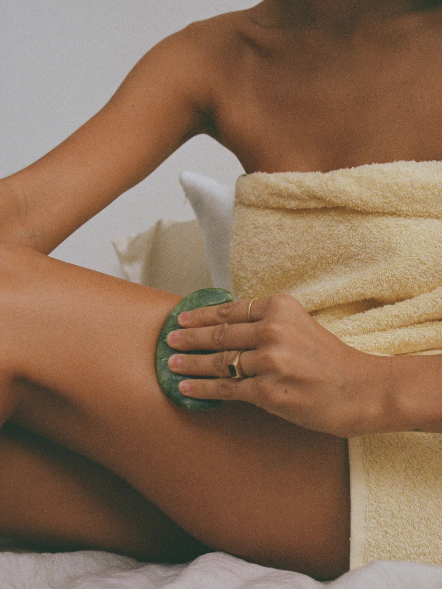 Woman using the HINU Jade Scalp Stimulator on her thigh