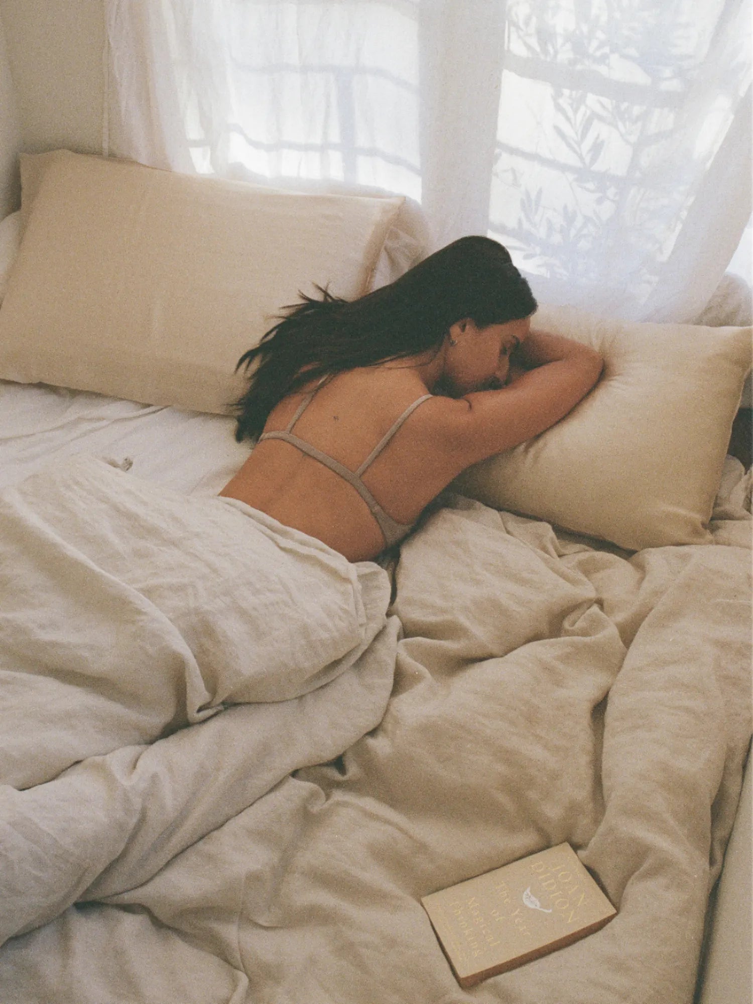 Woman resting face down on the HINU Hair Protect Pillowcase in bed