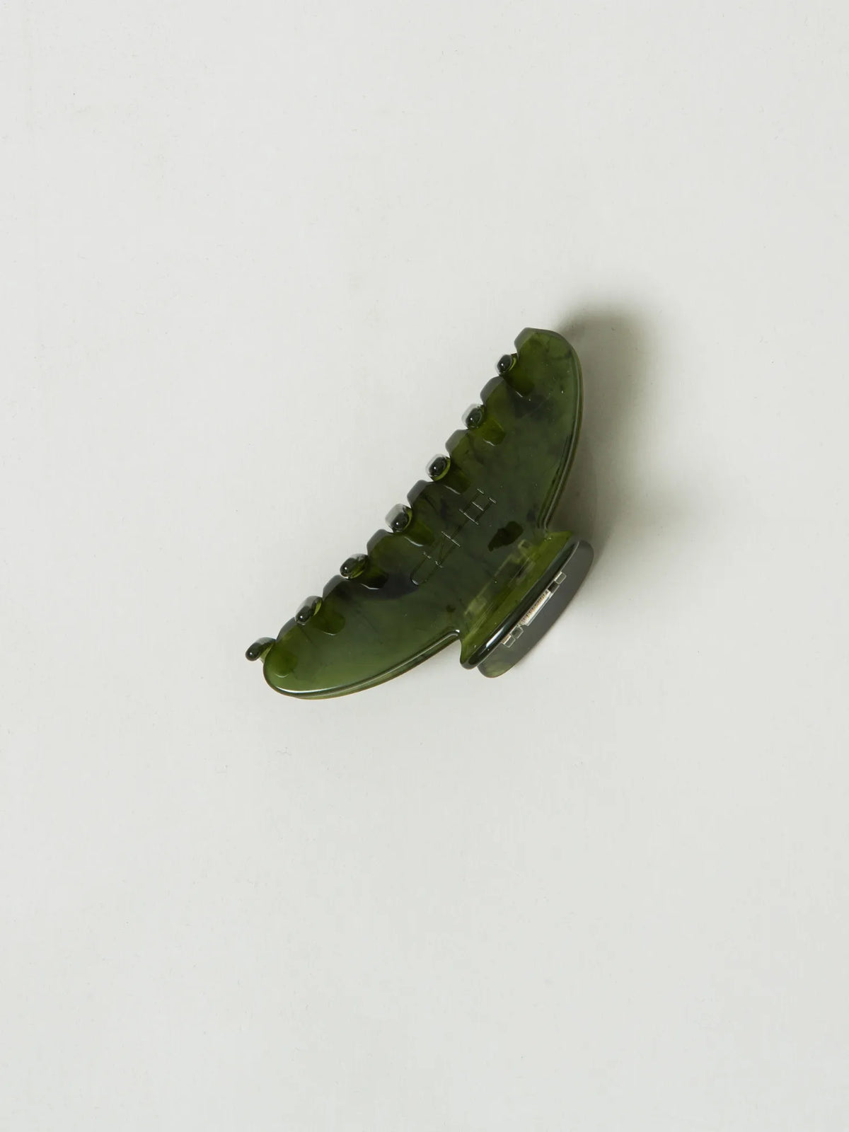 Angled side view of the translucent green HINU Rimu Claw Clip