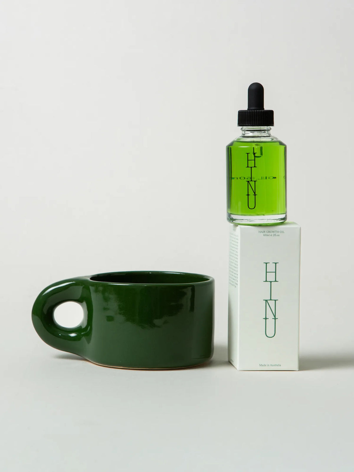 HINU Hair Growth Oil and green Ritual Mug displayed with product packaging