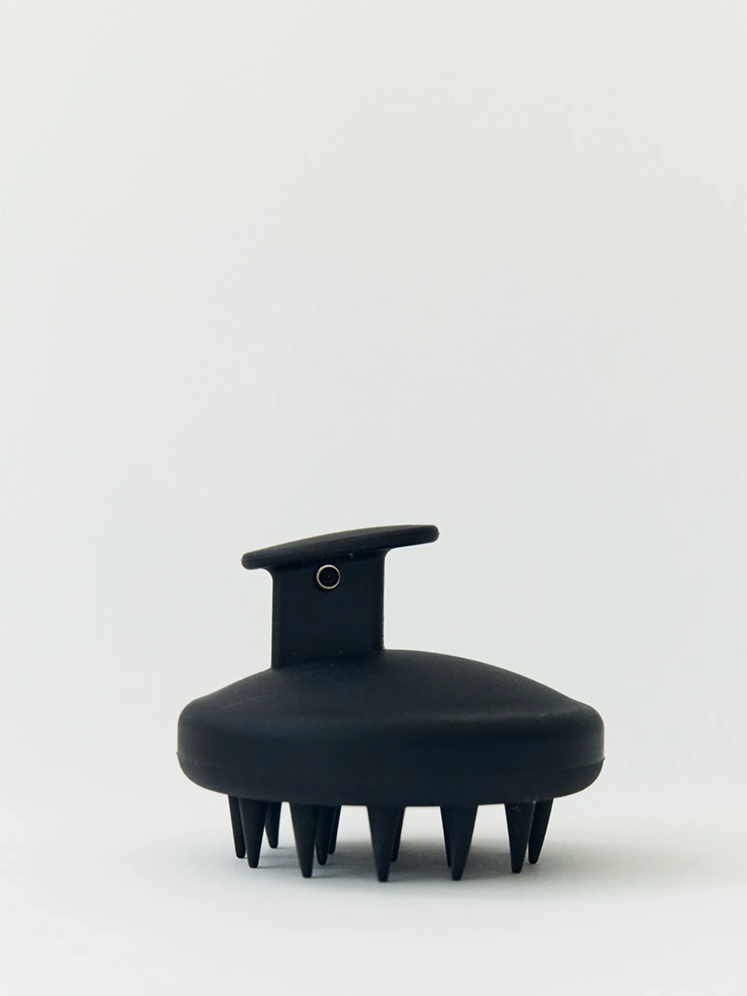 Front view of the black HINU Scalp Massager on an off-white background