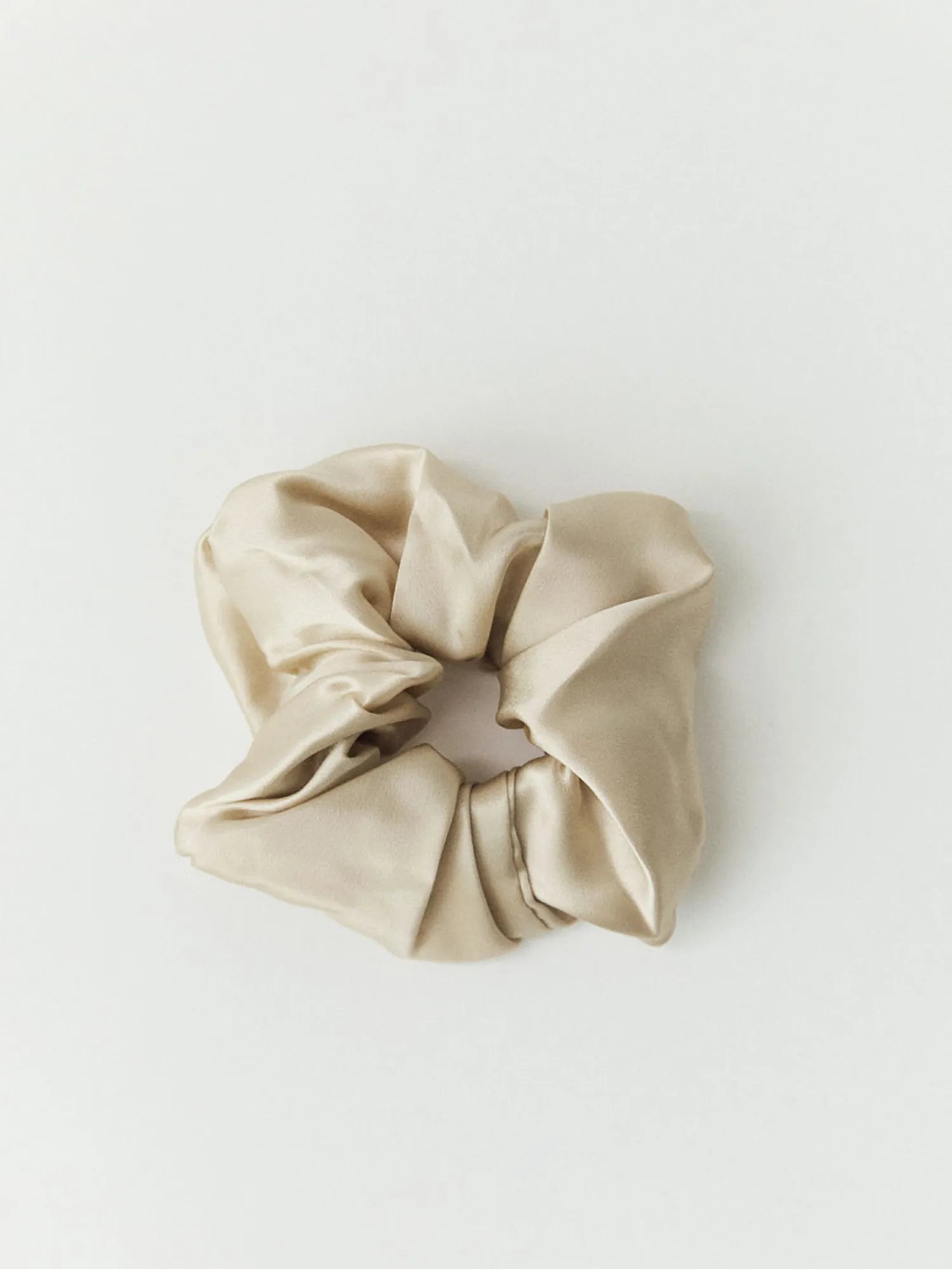 Oat-coloured HINU Silk Scrunchie on an off-white background