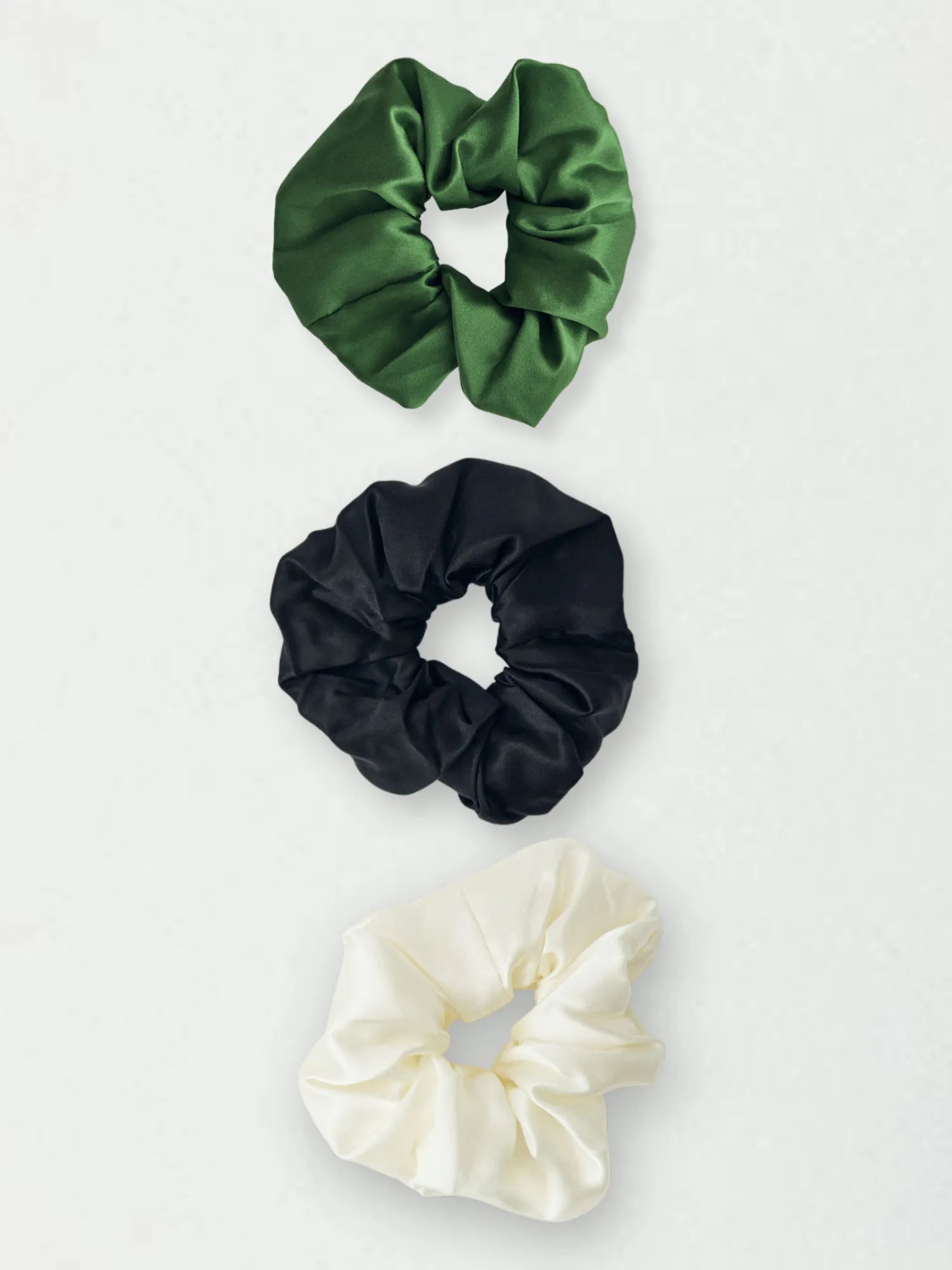Three HINU Silk Scrunchies in forest green, black and cream