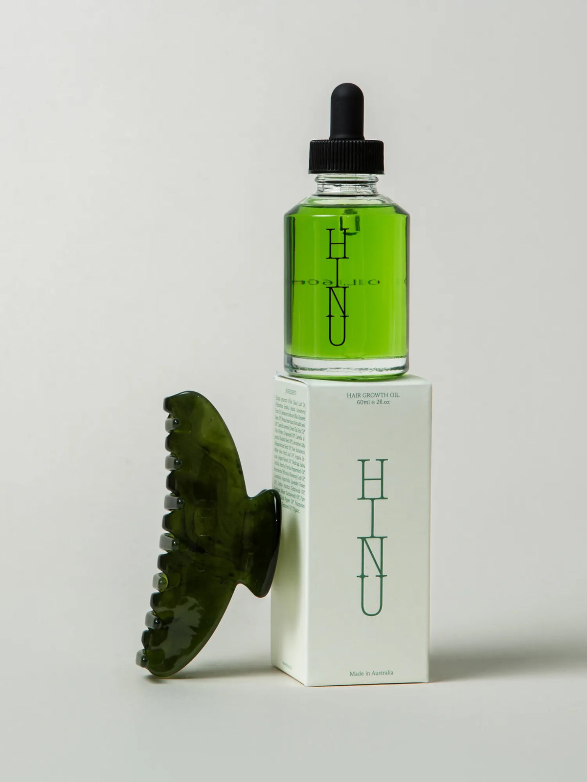 HINU Hair Growth Oil and Rimu Claw Clip displayed with product packaging