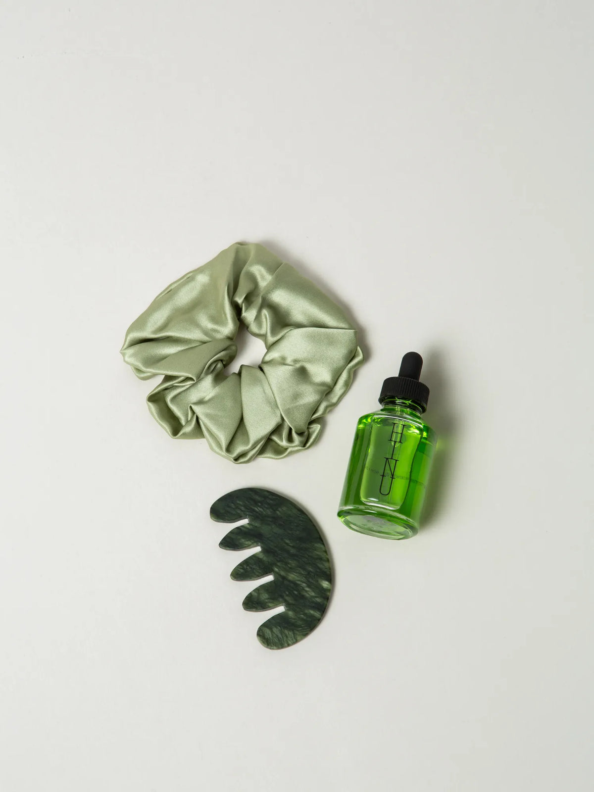 Overhead view of HINU Jade Ritual Set products on an off-white background