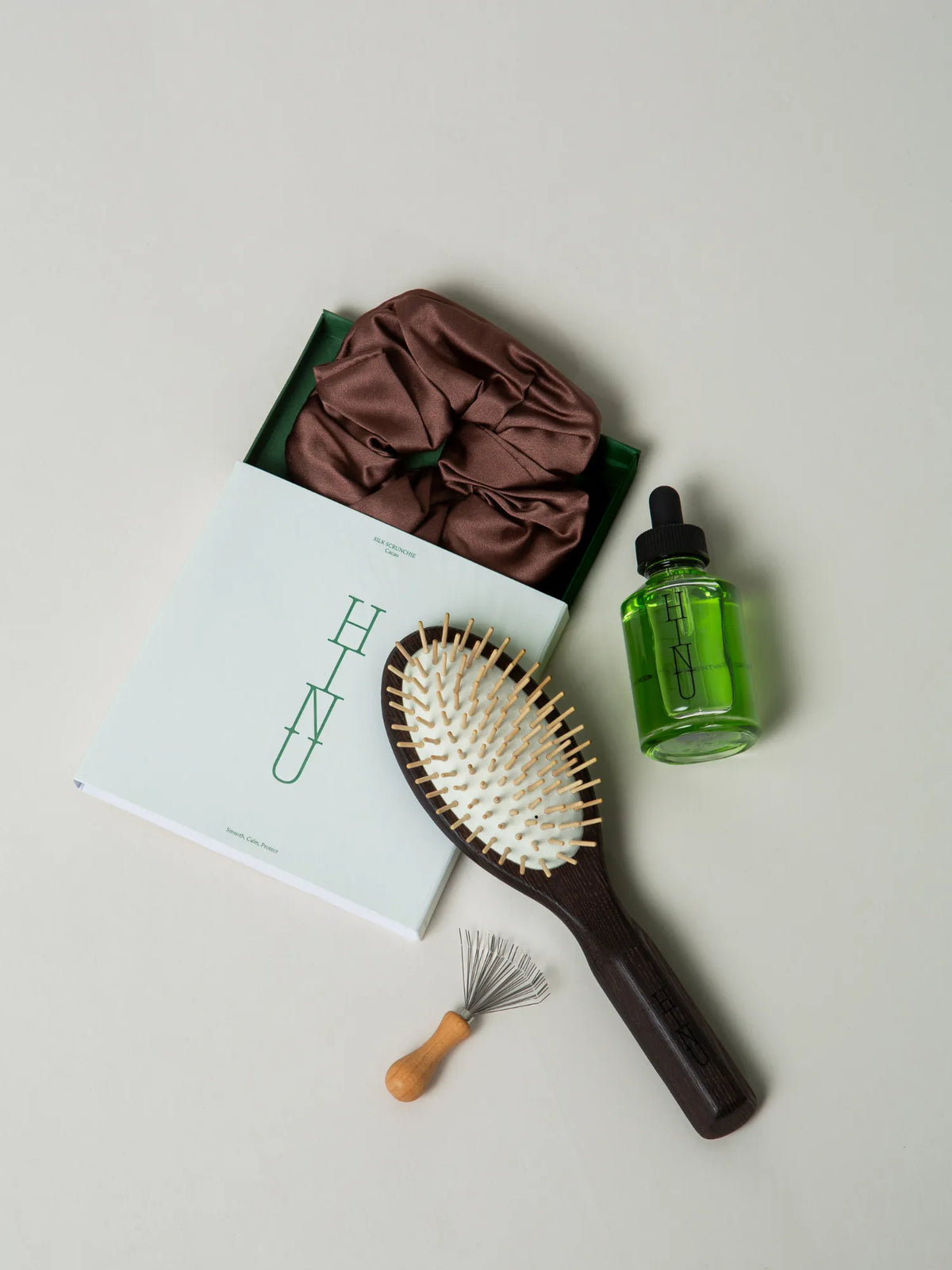HINU Foundational Kit with packaging, brown scrunchie, oil, brush and cleaner