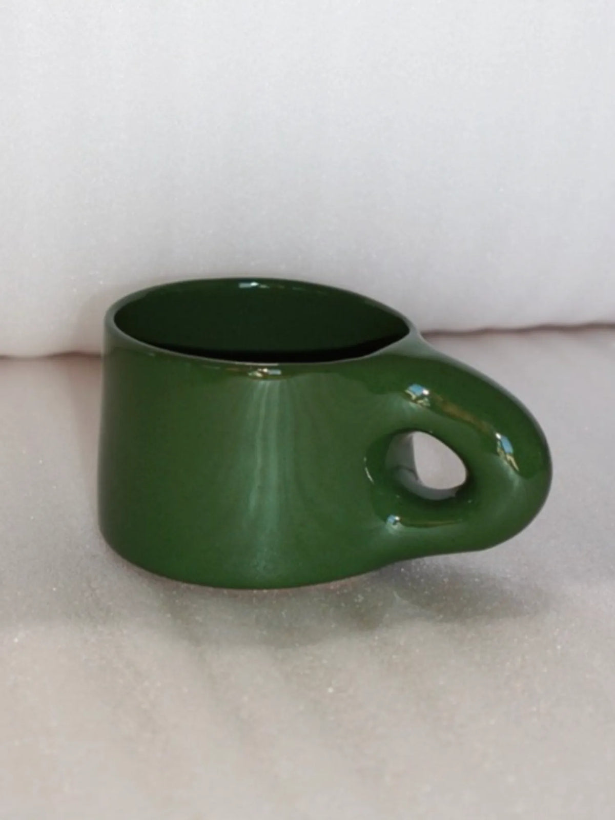 Green HINU Ritual Mug displayed on soft white fabric