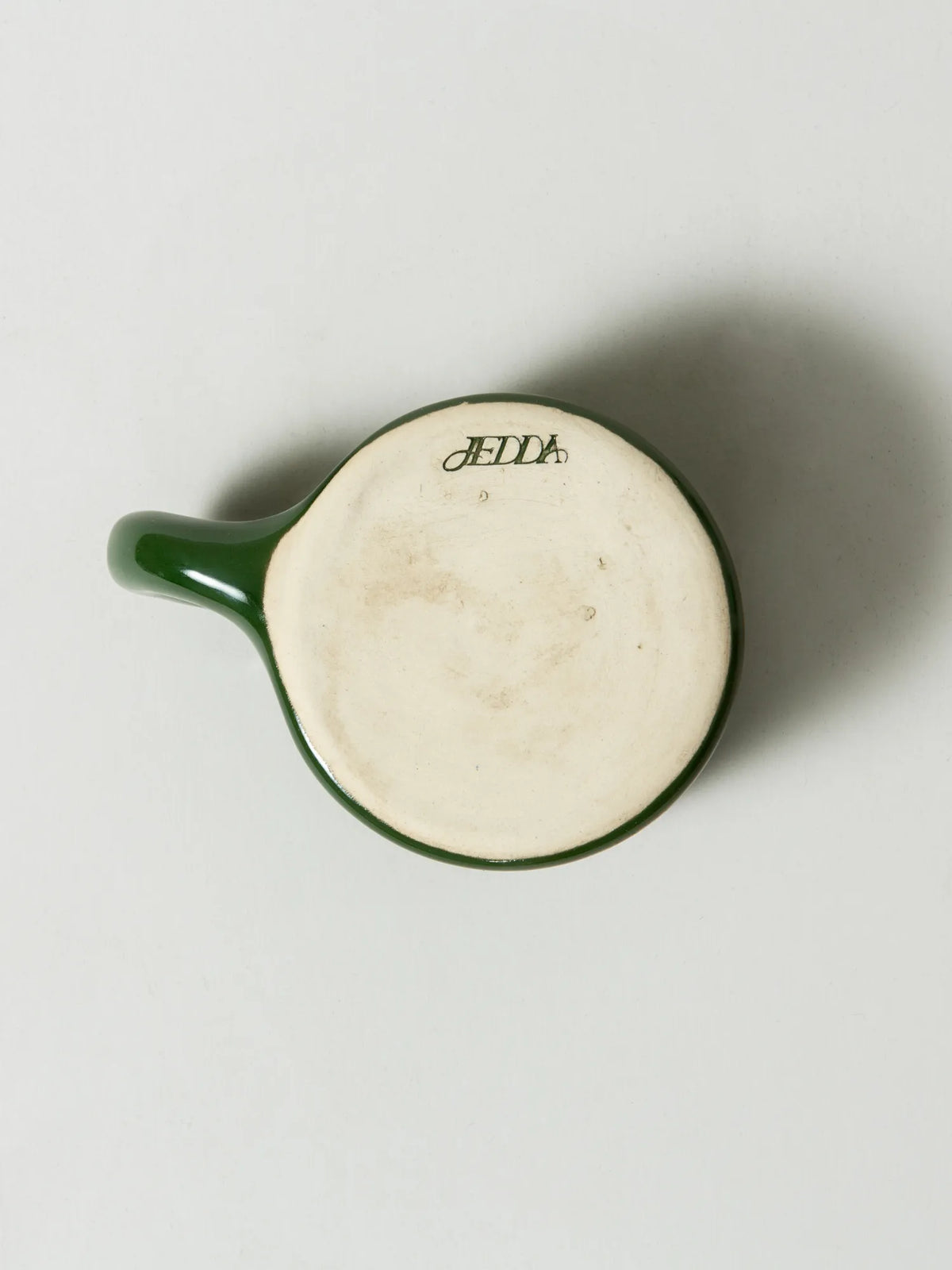Underside of the handcrafted green HINU Ritual Mug showing the maker's mark