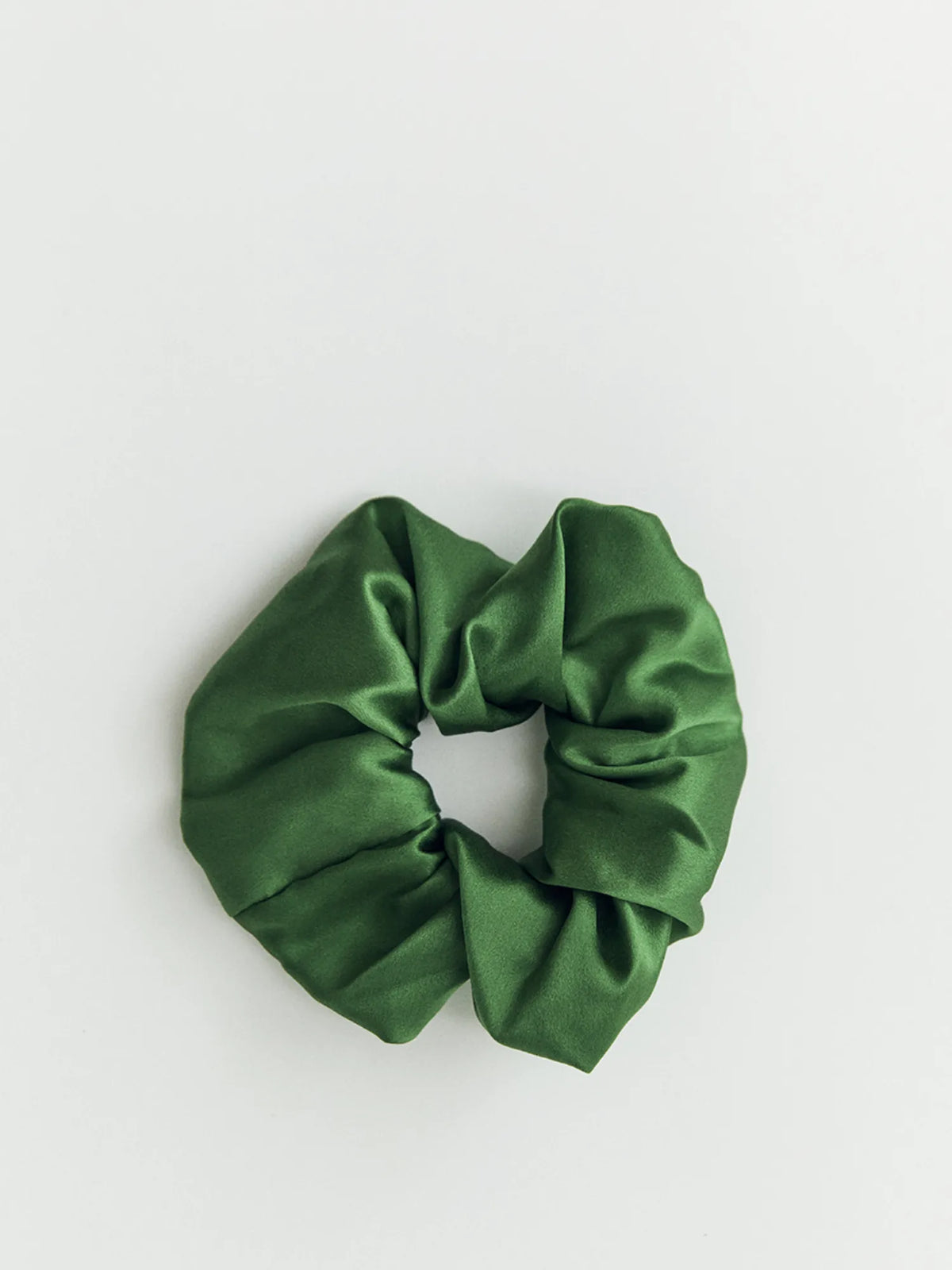 Forest green HINU Silk Scrunchie on an off-white background
