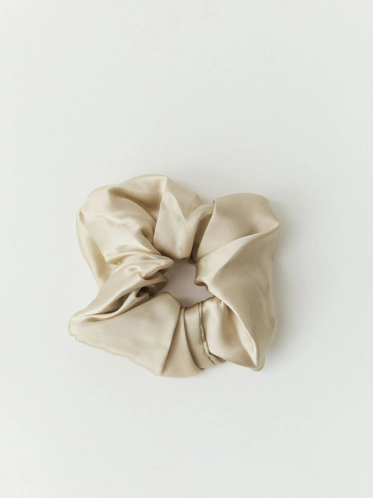 Oat-coloured HINU Silk Scrunchie on an off-white background