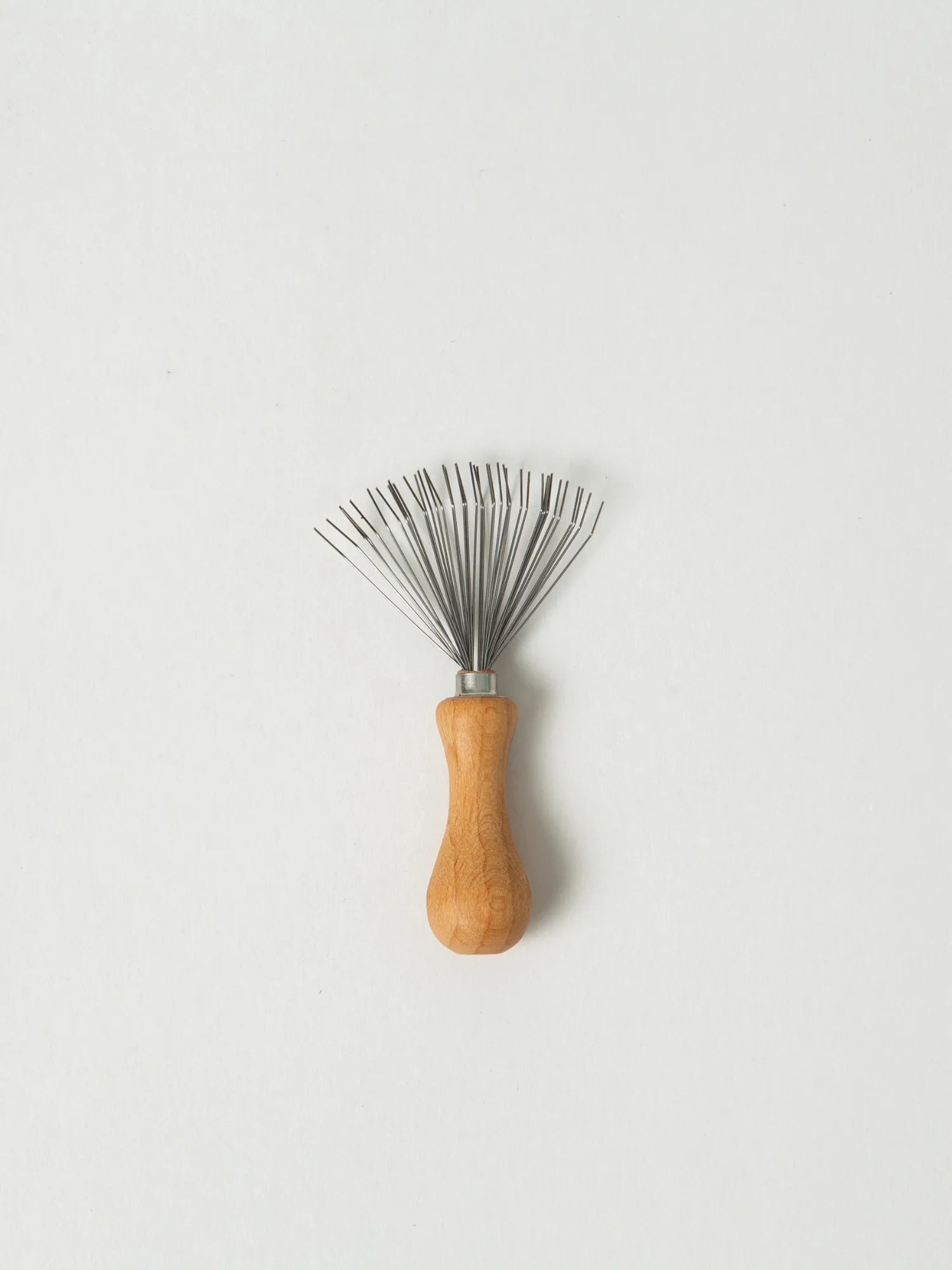 HINU Hair Brush Cleaner with wooden handle and metal bristles on white